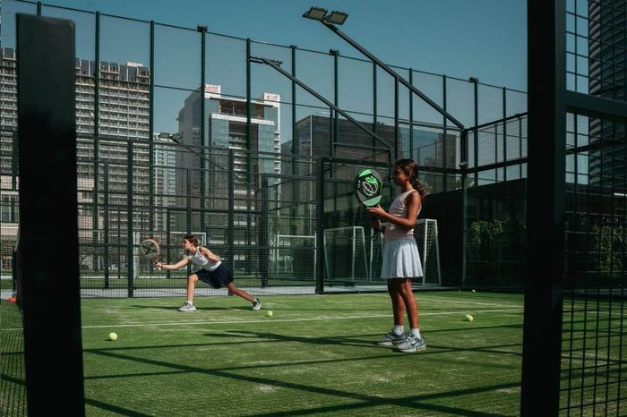 Padel match in play, Downtown towers behind the glass